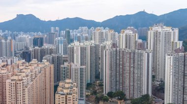 Kalabalık caddelerin ve yeşilliklerin üzerinde uzun apartmanlar yükseliyor. 8 Şubat 2026