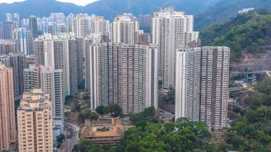 Kalabalık caddelerin ve yeşilliklerin üzerinde uzun apartmanlar yükseliyor. 8 Şubat 2026