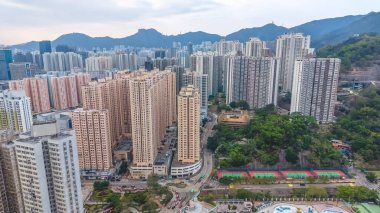 Kalabalık caddelerin ve yeşilliklerin üzerinde uzun apartmanlar yükseliyor. 8 Şubat 2026