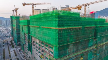 8 Şubat 2026 'da vinçlerin altındaki yeşil iskeleye sarılı büyük bir hastane yapısı.