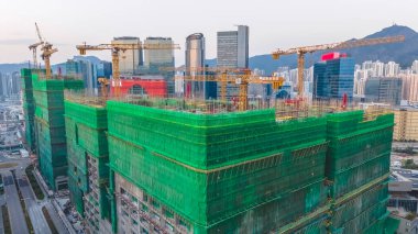 8 Şubat 2026 'da vinçlerin altındaki yeşil iskeleye sarılı büyük bir hastane yapısı.