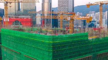 8 Şubat 2026 'da vinçlerin altındaki yeşil iskeleye sarılı büyük bir hastane yapısı.