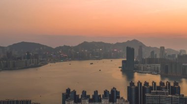 Akşam erken saatlerde parlayan Kowloon Körfezi silueti. 8 Şubat 2026