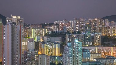 Dağ siluetinin altında yoğun yüksek kuleler parıldıyor. 8 Şubat 2026