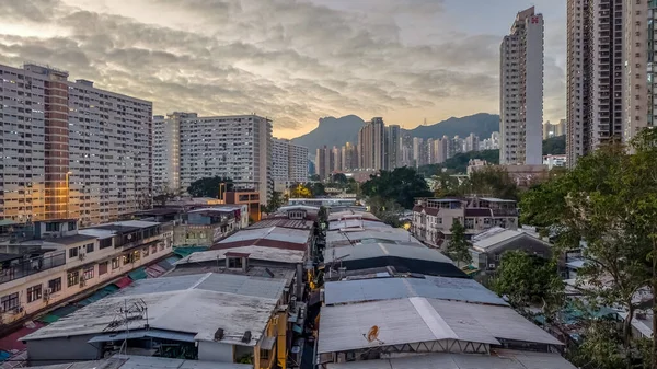 Tarihsel köy çatıları, 5 Şubat 2026 'da günbatımında modern kulelere tezat oluşturuyor.