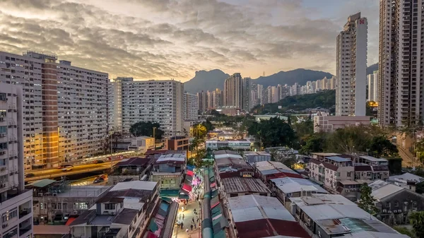 Tarihsel köy çatıları, 5 Şubat 2026 'da günbatımında modern kulelere tezat oluşturuyor.