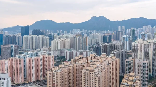 Yoğun yüksek katlı kümeler bulutlu gökyüzü altında şehir manzarası boyunca uzanır. 8 Şubat 2026