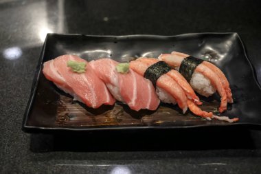 Üzerinde 24 Kasım 2025 tarihli wasabi No.lu ton balığı ve yılan balığı bulunan bir tabak taze nigiri sushi.