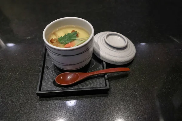 Beyaz seramik bardakta taze maydanoz garnitürüyle servis edilen kremalı çorba. 24 Kasım 2025