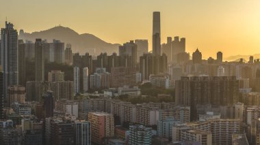 Katmanlı yerleşim kuleleri altın sisler boyunca yükseliyor. Akşam manzarası 15 Şubat 2026