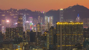 Yüksek kuleler canlı turuncu alacakaranlık ufkuna karşı yükseliyor. 15 Şubat 2026