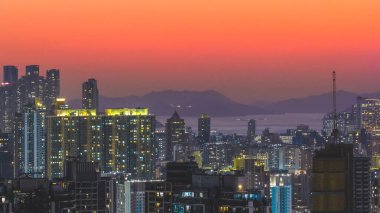 Yüksek kuleler canlı turuncu alacakaranlık ufkuna karşı yükseliyor. 15 Şubat 2026