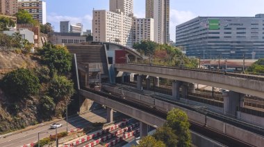 Elektrik banliyö treni, binaların yanındaki yüksek raylar boyunca hareket ediyor, 16 Şubat 2026