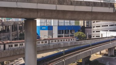 Elektrik banliyö treni, binaların yanındaki yüksek raylar boyunca hareket ediyor, 16 Şubat 2026