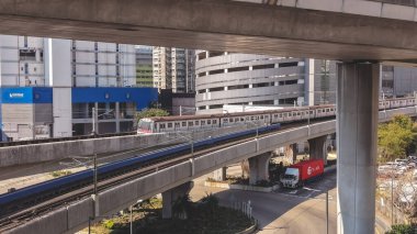 Elektrik banliyö treni, binaların yanındaki yüksek raylar boyunca hareket ediyor, 16 Şubat 2026