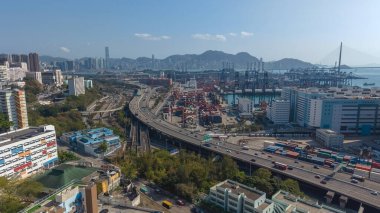 Turnalar ve uzak dağların yanında büyük yükseltilmiş otoyol kıvrımları, 16 Şubat 2026