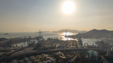 Geniş konteynır portu 16 Şubat 2026 'da ılık puslu akşam ışığı altında parlıyor.