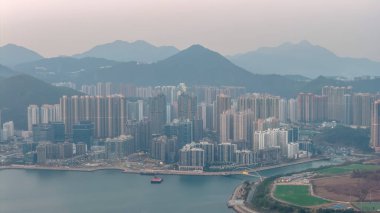 Yoğun kentsel ufuk çizgisi, 22 Şubat 2026 'da akşam limanı sularında usulca yansıyor.