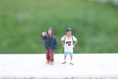 İki küçük heykel, parlak düz platformda sakince poz veriyor.