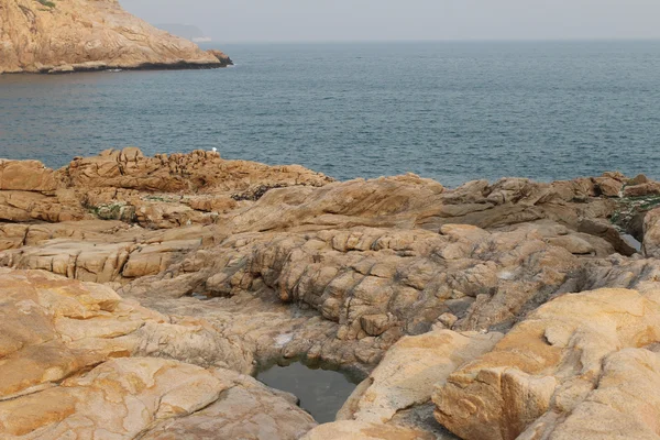 Costa rocosa del mar y el agua borrosa en shek o — Foto de Stock