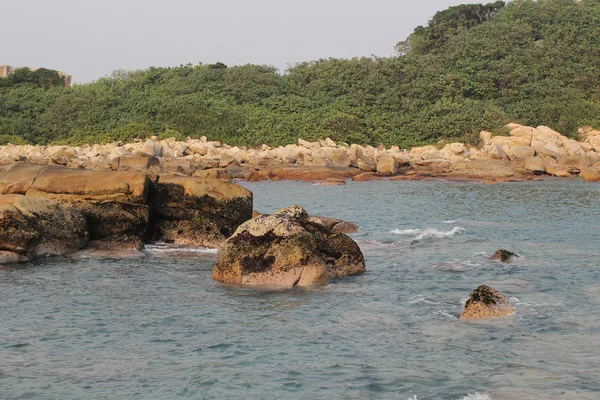 Steniga havskust och suddiga vatten i shek o — Stockfoto