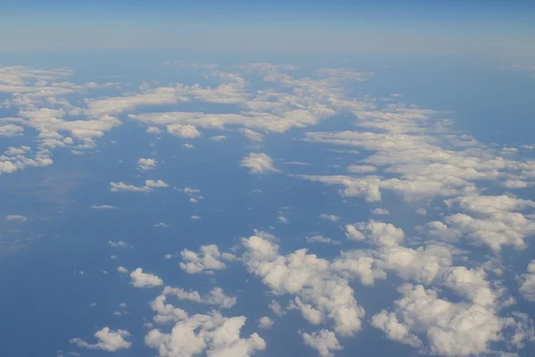 Luftaufnahme von blauem Himmel und Wolkendecke aus dem Flugzeugfenster — Stockfoto