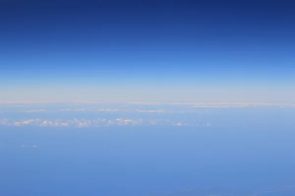 Luftaufnahme von blauem Himmel und Wolkendecke aus dem Flugzeugfenster — Stockfoto