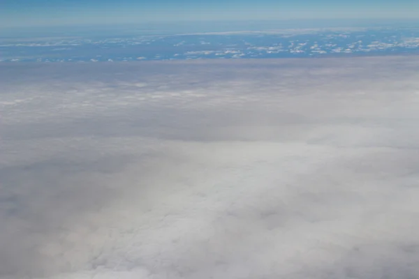 Ett flygplan som flyger i den blå himlen — Stockfoto