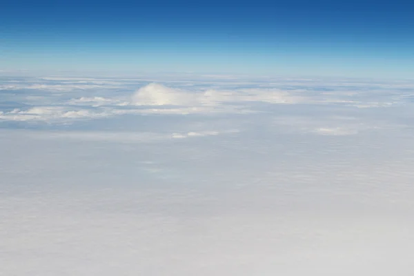 Luftaufnahme von blauem Himmel und Wolkendecke aus dem Flugzeugfenster — Stockfoto