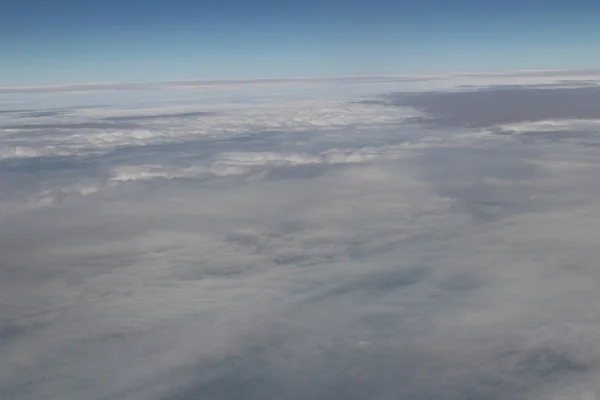 Ein Flugzeug fliegt in den blauen Himmel — Stockfoto