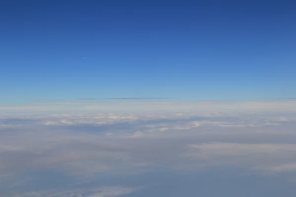 Egy repülőgép repül a kék ég — Stock Fotó