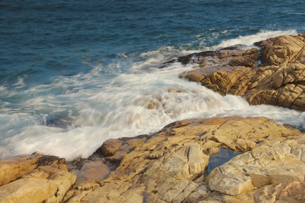 Felsige Meeresküste und verschwommenes Wasser in shek o, hong kong — Stockfoto