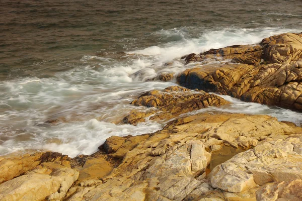 Skalnaté moře pobřeží a rozmazané vody v shek o, Hong Kong — Stock fotografie