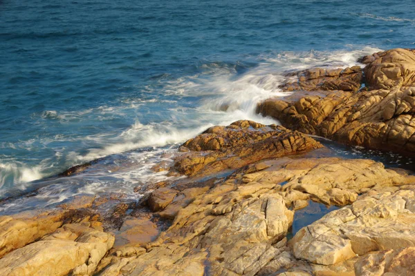 Skaliste wybrzeże morskie i zamazana woda w shek o, hong kong — Zdjęcie stockowe