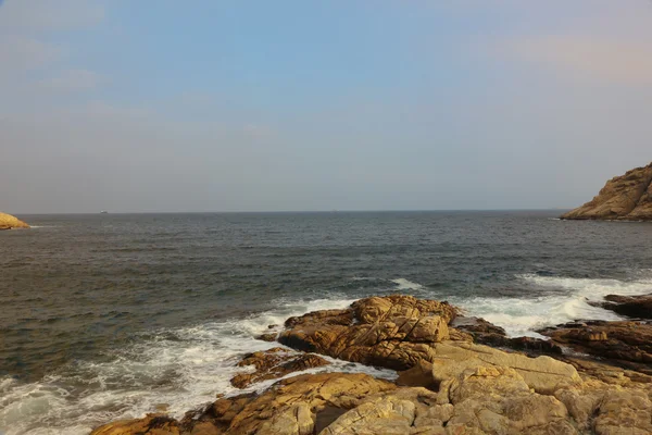 Costa del mar rocoso y agua borrosa en shek o, hong kong — Foto de Stock