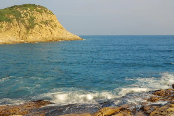 Rotsachtige kust en wazig water in shek o, hong kong — Stockfoto