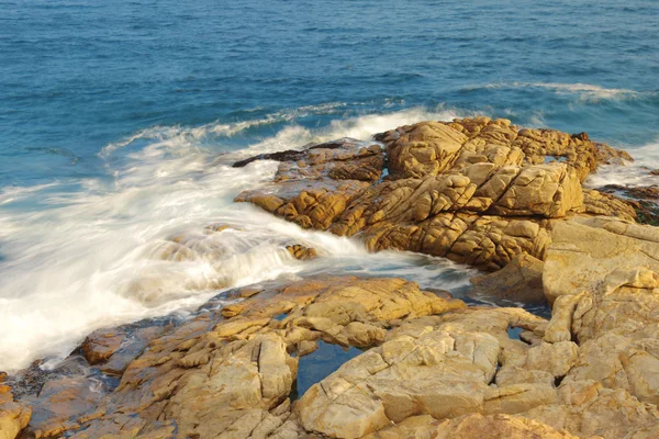 Klippig havskust och suddigt vatten i shek o, hong kong — Stockfoto