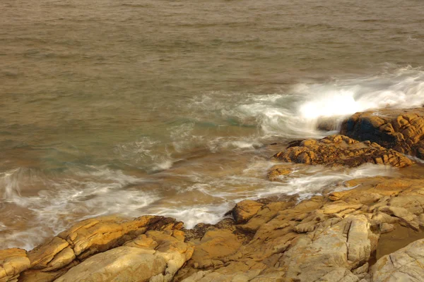 Skaliste wybrzeże morskie i zamazana woda w shek o, hong kong — Zdjęcie stockowe