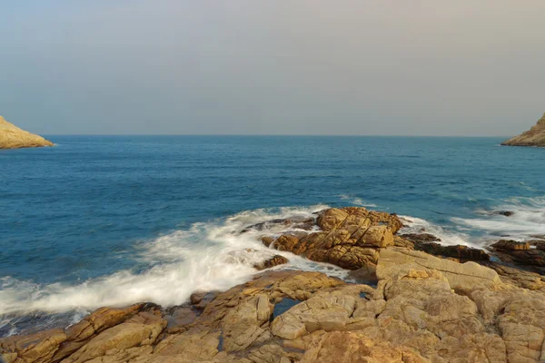 Felsige Meeresküste und verschwommenes Wasser in shek o, hong kong — Stockfoto