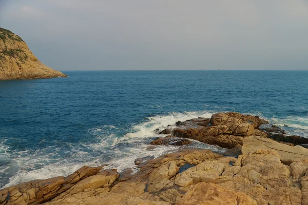 Costa del mar rocoso y agua borrosa en shek o, hong kong — Foto de Stock