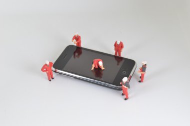 telefonda ayakta minyatür işçi