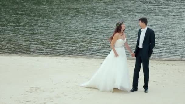 Жених и невеста стоят у озера. Slow Motion — стоковое видео