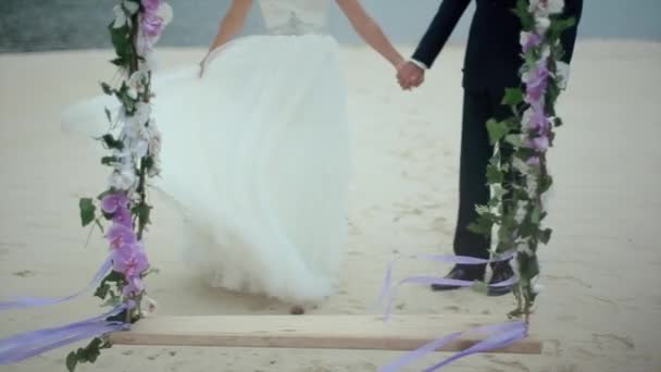 Невеста размахивает платьем держит за руку жениха — стоковое видео