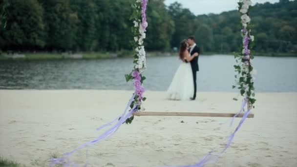 Свадебный букет на качелях с супружеской парой — стоковое видео