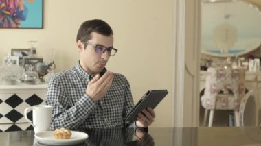 Genç bir adam onun Tablet o Hakes olarak bakar