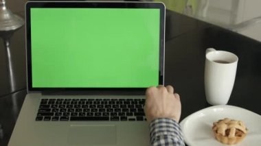 bir adam türleri masasının üzerindeki bir laptop.