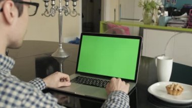 bir adam türleri masasının üzerindeki bir laptop.