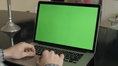 bir adam türleri masasının üzerindeki bir laptop.