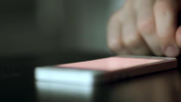 Téléphone portable sur la table poussé et balayé par le doigt — Video