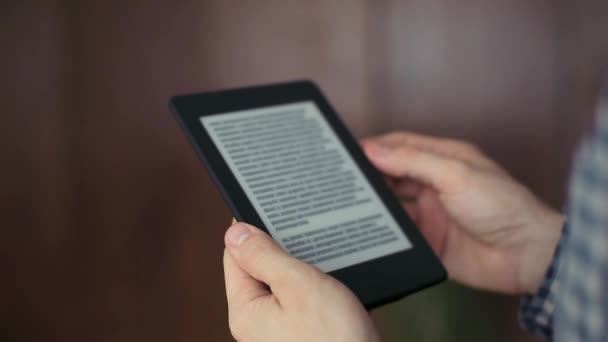 L'uomo legge un Ebook sul suo computer tablet Indoor — Video Stock